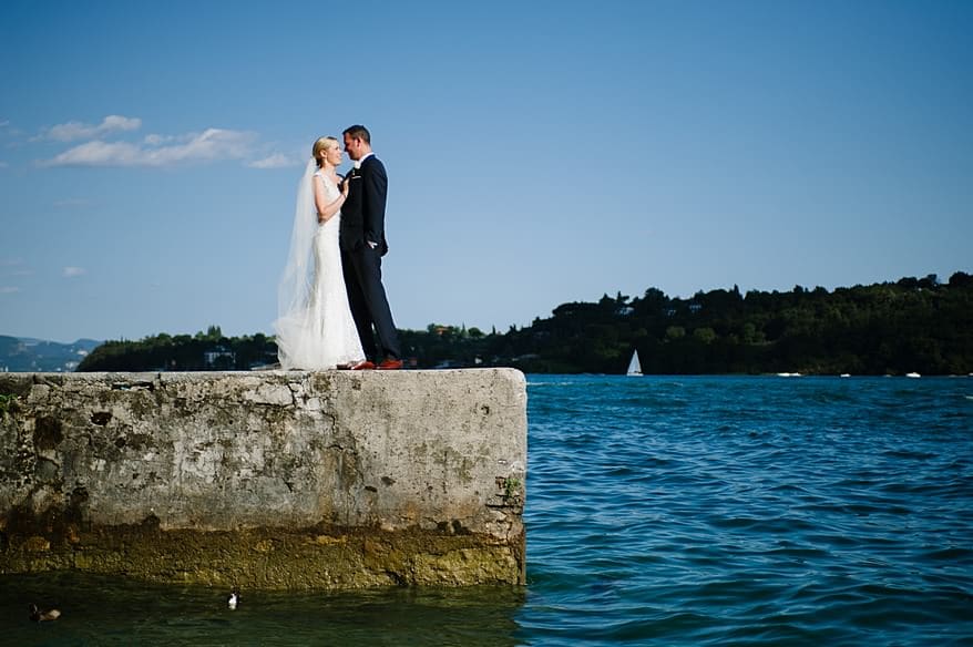 bride and grooms stood on the a pier at Lake Garda in Italy