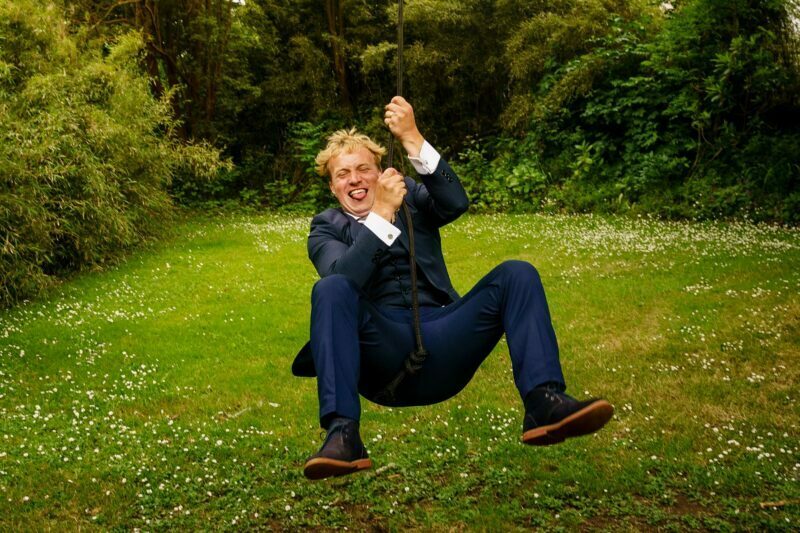 Cornish Camels Wedding Photographer 39 groom on the rope swing at cornish camels